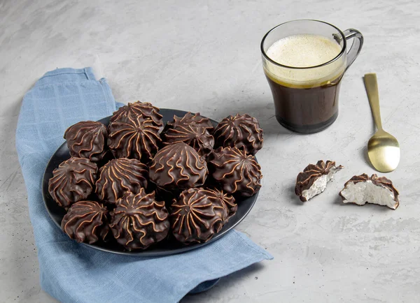 Mavi keten kumaş üzerinde bir fincan kahve ile marşmelov..