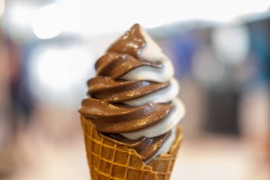 Vanilyalı ve çikolatalı dondurma, waffle külahlı. Bulanık arkaplan.