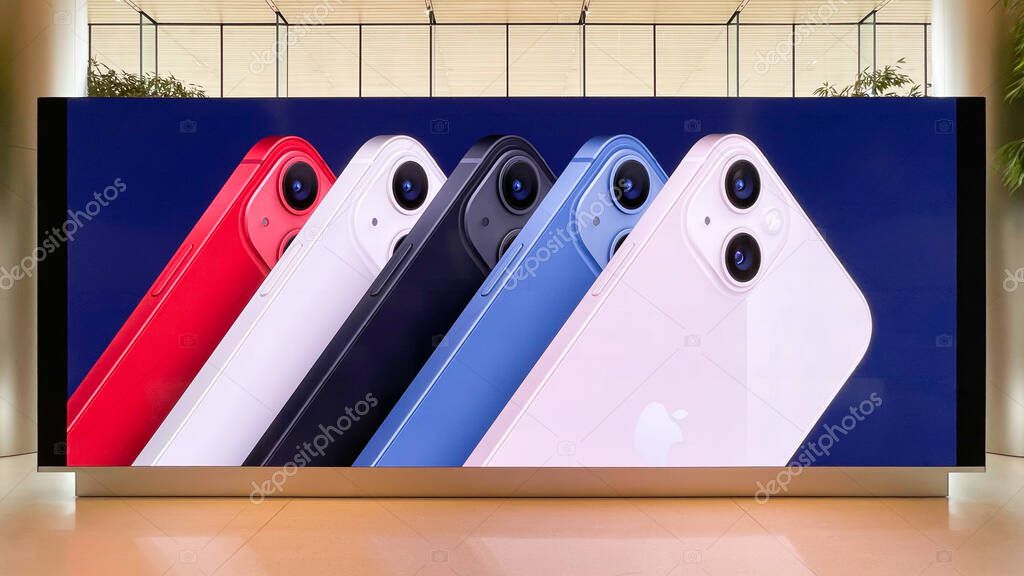 Bangkok, Thailand - Oct 11, 2021: Apple iPhone 13 smartphone new release in multiple colors, advertisement on ads display screen in shopping mall. Modern mobile phone technology marketing concept