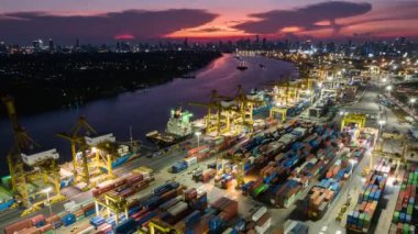 Bangkok, Thailand - Apr 25, 2022: Hyper lapse time-lapse of shipping port, cargo container ship, crane in Asia city at sunset. Logistic industry or freight transportation business. drone aerial view