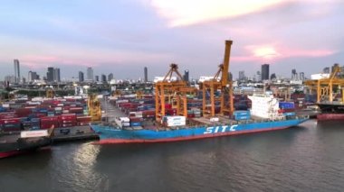 Bangkok, Tayland - 25 Nisan 2022: Asya 'da nakliye limanı, kargo konteynır gemisi, vinç ve araba trafiği. Lojistik endüstrisi veya nakliye sektörü iş konsepti, insansız hava aracı görüntüsü