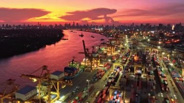 Bangkok, Tayland - 25 Nisan 2022: nakliye limanı, kargo konteynır gemisi, vinç, Asya 'da gün batımında araba trafiği. Lojistik endüstrisi, kargo taşımacılığı iş konsepti insansız hava aracı görüntüsü