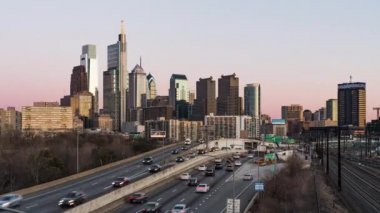 Day to night time-lapse of car traffic transport on multiple lanes highway road, financial district building in Philadelphia USA. America transportation, commuter lifestyle, American city life concept