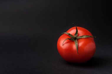 Koyu gri arkaplanda olgun kırmızı domates