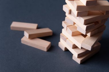 Gri-mavi arkaplanda tahta bloklardan yapılmış Jenga kulesi, metin için boşluk