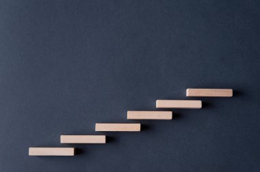 Gri-mavi arka planda tahta blok basamakları. Kavram. Ayağa kalkın. Yükseklik. Merdivenler. Terfi