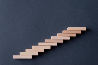 Gri-mavi arka planda tahta blok basamakları. Kavram. Ayağa kalkın. Yükseklik. Merdivenler. Terfi