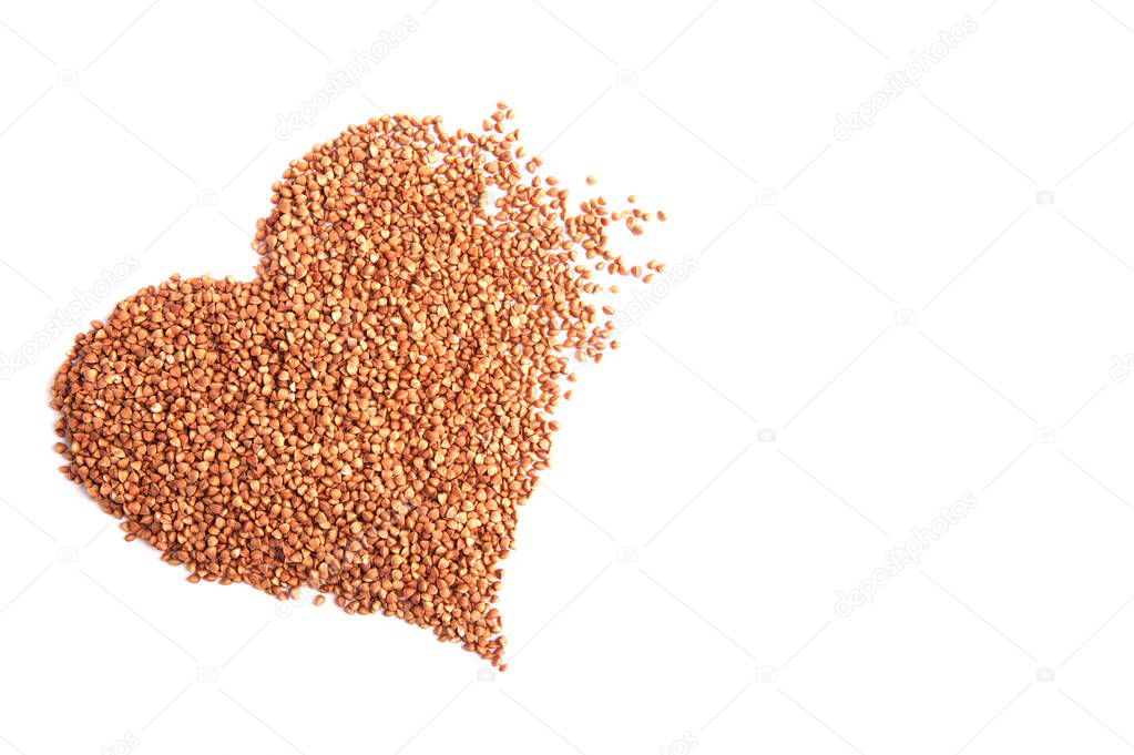 Heart from dry buckwheat groats on a white background top view. Love buckwheat
