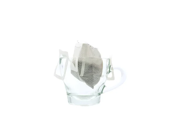 グラスマグカップの縁に支えられたコーヒーフィルターを持つ紙耳 — ストック写真