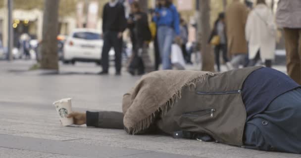 Mann übergibt Geld an unkenntlich auf Straße liegende Bettlerin — Stockvideo