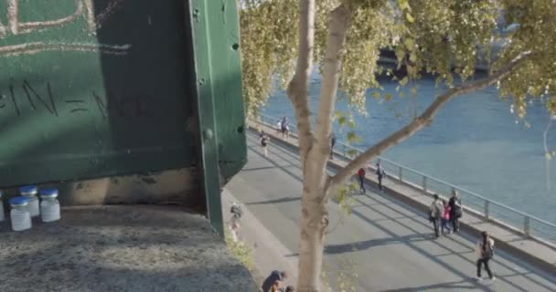 Pan de piétons marchant le long de la rivière vers des graffitis anti-vaccins en français — Video