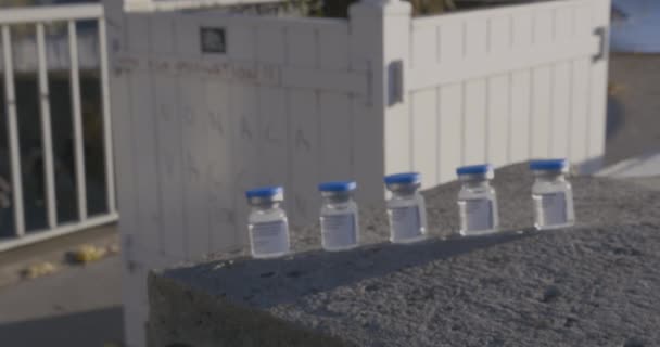 Focus sugli scaffali dei graffiti anti-vaccinazione in francese con bottiglie di vaccino — Video Stock