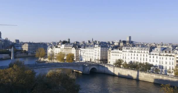 High angle pan shot of Paris skyline in afternoon with cathedral, buildings, bridge, river — Stock Video