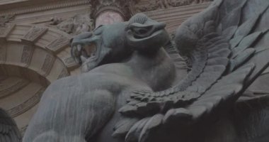 Yakın plan taş oyma mermer kanatlı ejderha arka planda bronzlaşmış anıt Place St. Michel