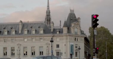 Önünde trafik ışığı olan Paris binalarının uzun görüş açılı görüntüleri. Kamera lamba direğinin arkasında.