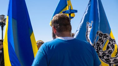 Ukrayna 'nın ortasında duran sakallı adam, mitinge bayrak dikme.