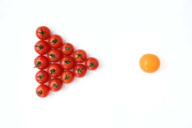 Kırmızı domatesler beyaz bir masaya ok şeklinde ve sarı bir domatesin yanına istiflenir. Bireysellik, karşıtlıklar, benzersizlik kavramı, bir diğeri. Kalabalıktan kaçıyorum. Biri farklı. Kalabalıktan uzaklaşmak..