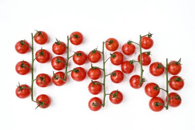 Beyaz bir masanın üzerinde kırmızı kiraz domatesleri.