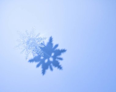 Mavi arkaplanda gölgeli kristal kar taneleri var. Noel, Yeni Yıl ve Kış Tatil Dekorasyonu, Yazdırma, Kutlama Kartı, Davetiye, Parti Pilotu vs. için Dekoratif Kar Tanesi.