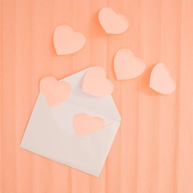 Pastel kayısı renkli kalpler zarfın içinde. Sevgililer Günü 'nde romantik bir kutlama. Düz yatış, minimal tatil kartı düz yatış, minimum tatil kartı..