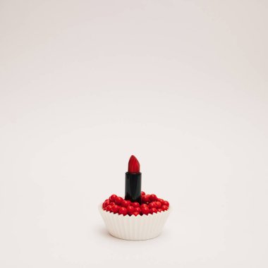 Beyaz arka planda kırmızı ruj ve kırmızı inci kolye. Boşluğu kopyala.