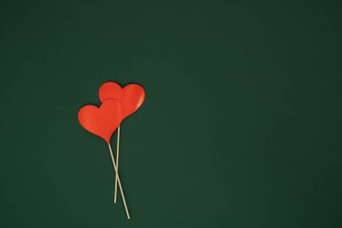 Koyu yeşil arka planda kırmızı kağıt kalp şekli dekorasyonu. Aşk konsepti. Düz yatıyordu.