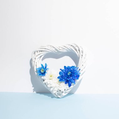 Güzel kalp şekli, çerçeve yapısı, mavi arka planda çeşitli taze çiçekler. Uzayı kopyala Sevgililer günü, anneler, kadınlar günü konsepti. Düz konum, üst görünüm. Şablon, düğün davetiyeleri tasarımı, kartlar..