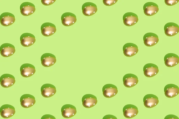パステルグリーンの背景に黄金の卵で作られたパターン 最小限のイースターやフードコンセプト スペースのコピー — ストック写真