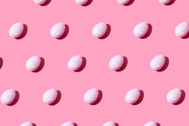 Pastel pembe arka planda pembe yumurtadan yapılmış desen. Asgari Paskalya veya gıda konsepti.