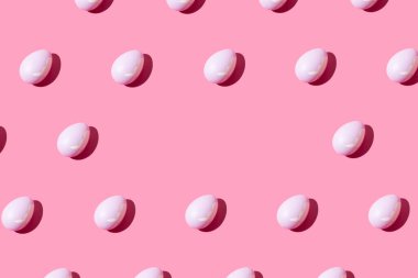 Pastel pembe arka planda pembe yumurtadan yapılmış desen. Asgari Paskalya ya da gıda konsepti. Kopyalama alanı ile.