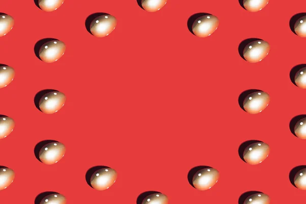 赤の背景に金色の卵で作られたパターン 最小限のイースターやフードコンセプト スペースのコピー — ストック写真