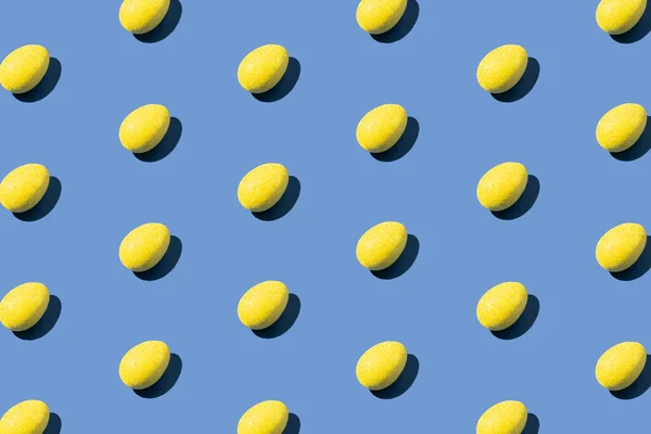 青い背景に黄色の卵で作られたパターン 最小限のイースターまたはフードコンセプト ストックフォト