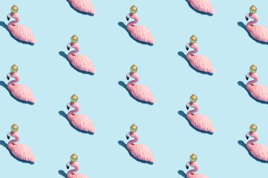 Parlak açık mavi arka planda pembe flamingo oyuncaklardan yapılan son moda güneş ışığı deseni. Asgari yaz konsepti.