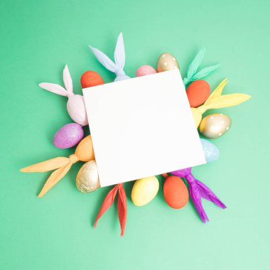 Renkli Paskalya yumurtaları ve tavşanlarla yapılmış yaratıcı bir düzen. Asgari doğa geçmişi. Bahar tatili konsepti. Boşluk kağıt kartını kopyala.