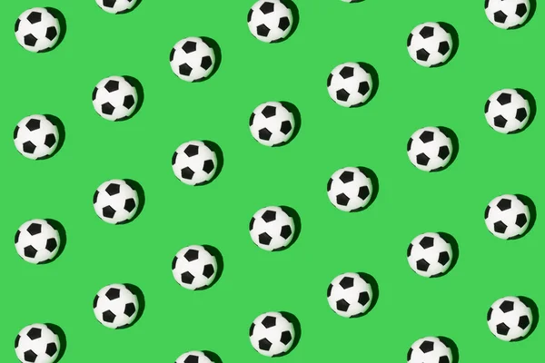 Seamless pattern made of football, soccer ball isolated on green background. Isometric view. Sport concept.