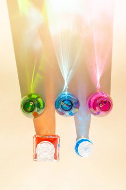 Kumlu arka planda soğuk içecekler olan renkli şişeler. Parlak renkli yansımalı gölgeler. Soyut estetik tasarım fikri. Güneşli plaj günü konsepti.