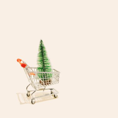Bir mağaza arabası olarak Noel alışverişi konsepti. Kara Cuma satışının sembolü olarak bayram çam ağacını taşıyor. Ya da satın alma hediyeleri ve satışlar internetten yapılıyor..