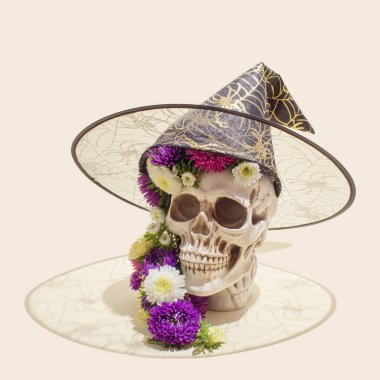 Renkli çiçekli ve cadı şapkalı gerçekçi bir insan kafatası. Estetik Meksika Ölüler Günü (Dia De Los Muertos) veya Cadılar Bayramı konsepti.