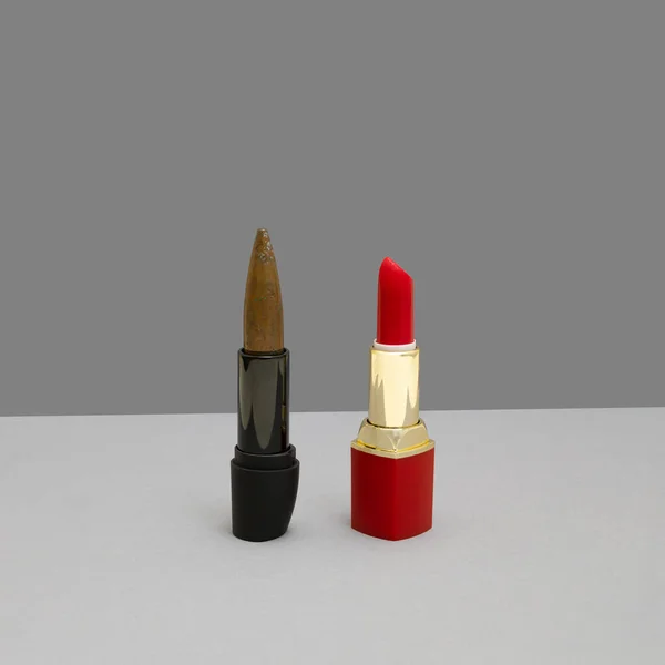 Lipstick and bullet in line. Feminine background for huntress or woman soldier.