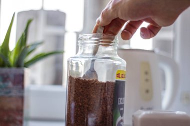 Bir adam, yorucu ve verimli bir gün için sabahları kendine kahve yapar.