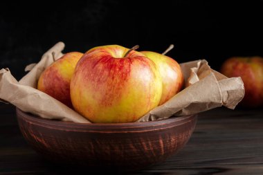 Koyu arkaplanda taze Gala elmaları. Kırmızı-sarı elmalar. Kırsal biçim