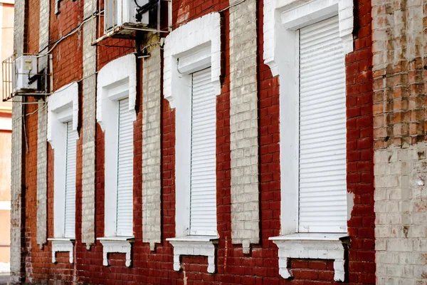 Brick House Windows with rolling shutter for house protection.