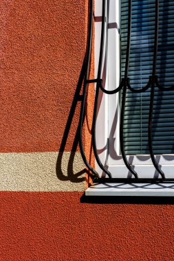 Duvardaki camlarda sahte metal parmaklıklar var. Soyguncu koruması. Şehirdeki yaşam güvencesi.