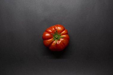 Tomato, red tomato on isolated black background, top view photo, fruit concept idea photo.