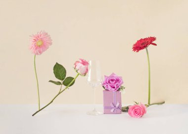 Çiçekler, hediye ve renkli bir arka planda cam. Yaratıcı romantik konsept. Asgari aşk fikri