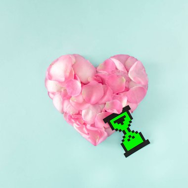 Mavi arka planda pembe gül yapraklarından yapılmış bir kalp. Minimum konsept. Düz yatıyordu.