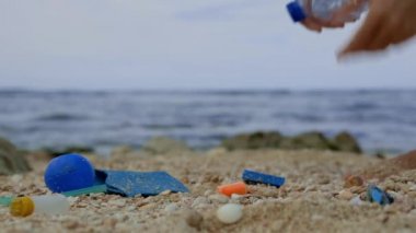 Plastik atıklardan plajı temizleyen genç bir kadın dünya okyanuslarını kirlilikten koruyan deniz yürüyüşleri yapıyor.