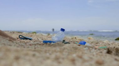 Plastik atıklardan plajı temizleyen genç bir kadın dünya okyanuslarını kirlilikten koruyan deniz yürüyüşleri yapıyor.