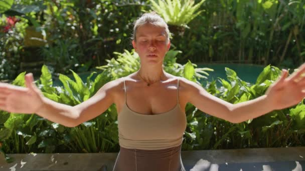 孕妇在家里做瑜伽姿势 背靠花园 抱着肚子 阳光普照的夏夜 — 图库视频影像