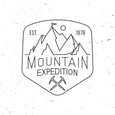 Dağ keşif rozeti. Vektör çizimi. Gömlek, logo, baskı, pul ya da tişört konsepti. Buz baltası ve dağ silueti ile klasik sanat tasarımı. Açık hava macera amblemi.